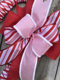 a red and white wreath with pink ribbon