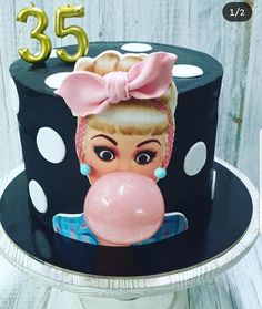 a birthday cake decorated with an image of a woman blowing a gummy bubble on top