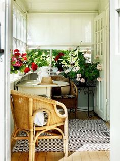 an open door leading into a room with flowers in the window and potted plants