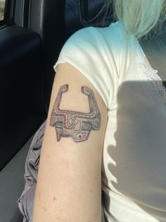 a woman with a tattoo on her arm sitting in a car