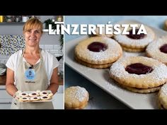 a woman holding a tray full of cookies next to a plate with jam on it