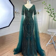 Emerald Elegance: 2024 Luxury Evening Dresses with Cape Sleeves in Rose Gold and Gray Fitted Dark Green Evening Dress, Dark Green Evening Dress For Gala, Dark Green Gala Evening Dress, Fitted Dark Green Evening Dress For Gala, Luxury Green Dress For Gala, Luxury Green Gala Dress, Luxury Green Formal Dress, Elegant Dark Green Gala Dress, Luxury Green Floor-length Dress