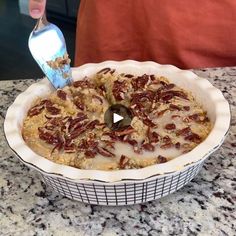 a pie with pecans in it being drizzled with milk