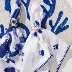 two blue and white napkins sitting on top of a table