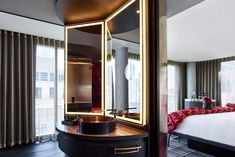 a hotel room with a bed, mirror and sink in it's corner area