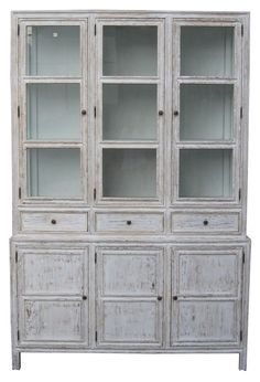 an old white china cabinet with glass doors and drawers on one side, against a white background