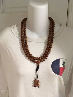 "Bodhi seed mala necklace made of 108 12mm beads with a Bodhi seed guru bead and an adjustable knot that allows you to change the length and tightness of the beads. Bodhi seeds are usually not polished so they are a solid color with small ridges or veins. Bodhi in Sanskrit translates to \"enlightened\" or \"awakened,\" therefore the Bodhi seed means \"enlightened seed.\" Bodhi is also a term in Buddhism to reflect a Buddha's understanding of the true nature of things. Many Buddhist wear the Bodh Holistic Necklaces With 8mm Beads For Rituals, Spiritual Wooden Beads Mala For Meditation, Spiritual Wooden Beads Necklace For Meditation, Holistic Necklaces With 8mm Beads For Festivals, Traditional Wooden Beads Necklace For Meditation, Traditional Jewelry For Meditation With 8mm Beads, Traditional Wooden Bead Necklaces For Meditation, Traditional 8mm Beads Jewelry For Meditation, Traditional Jewelry With 8mm Beads For Meditation