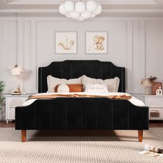 a bedroom with white walls and black bedding in the center is decorated with gold accents