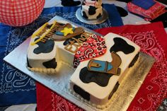 two decorated cakes sitting on top of a red and blue table cloth next to each other