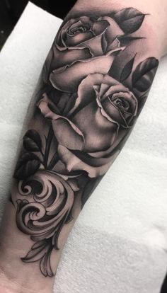 a black and white rose tattoo on the arm