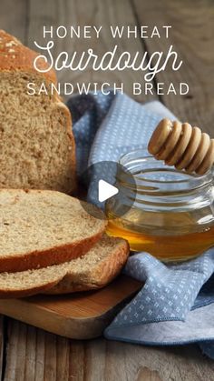 honey wheat sandwich bread on a cutting board with a jar of honey in the background