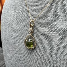 This hand-twisted pendant cradles a free form oval Peridot in a minimal prong setting. Chain Sold Separately Material: 14k Yellow Gold Stone Type: PeridotStone Size: 9mm x 7.5mm Diamond Quality: SI1GH Diamond Size: 2mm Diamond Weight: .03ct Chain: Sold separately; add to cart below. Shown with 1.0mm Solid Cable Chain. Dimensions: 29mm x 14mm Finish: high polish Weight: 2.5g Yellow Gold Oval Wire Wrapped Necklace, Elegant Peridot Birthstone Gemstones, Yellow Gold Peridot Teardrop Jewelry, Oval Peridot Jewelry For Formal Occasions, Formal Oval Peridot Jewelry, Gold Stone, Diamond Sizes, Cable Chain, Prong Setting