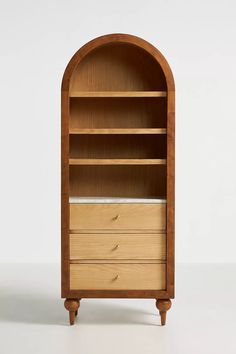 a wooden bookcase with two drawers and an arched shelf