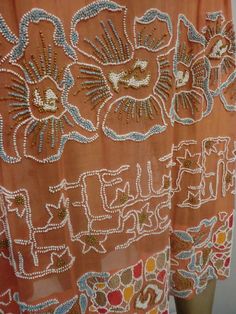 an orange dress with beadings and flowers on it