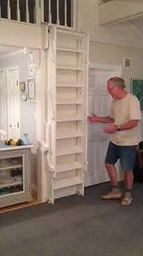 a man standing in front of a white refrigerator freezer next to a shelf filled with items