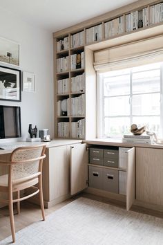 a desk and chair in a small room with bookshelves on the wall behind it