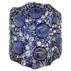 A lovely accent to any outfit! This gold ring features both smooth cabochon shaped sapphires along with round-brilliant cut blue sapphires. The cabochons weigh 4.16 carats while the round shaped sapphires weigh a total of 3.61 carats and are of different shades of blue giving the ring contrast in color. Made in 18k white gold and ready to be loved and enjoyed. Ring Size 6 Sapphire Cocktail Ring, Round Sapphire, Gold Cocktail Ring, Gold Cocktail, To Be Loved, Cocktail Ring, Cocktail Rings, Round Brilliant, Shades Of Blue