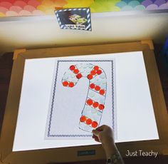 a person is making a candy cane craft on a projector screen with colored paper