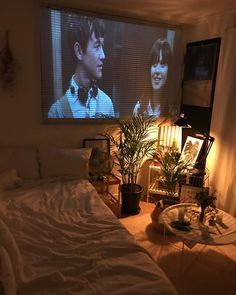 a bedroom with a large screen tv on the wall