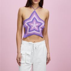 a woman in white pants and a purple top with a star on it's chest