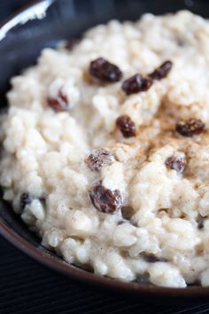 a bowl filled with oatmeal and raisins sitting on top of a table