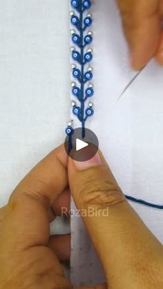 someone is working with beads on a piece of fabric that has been stitched together