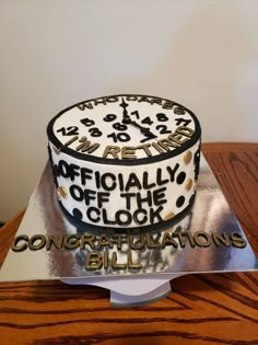 there is a cake on the table with congratulations written in gold and black lettering that reads,