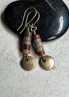 "red creek jasper earrings   small dangle boho earrings These earrings feature a small stack of Red Creek Jasper heishi stones. The earthy colors include green, golden yellow and rusty brown. Dangling below them is a small antiqued brass disc. Hook ear wires are antiqued brass. Length of earrings from top of ear wires is 1 1/2\". Jasper stones measure 4mm diameter. You can enter my shop here: gypsydangles.etsy.com" Beading Tips, Red Creek Jasper, Jasper Earrings, Boho Green, Square Earrings, Exeter, Jasper Stone, Red Jasper, Earthy Colors