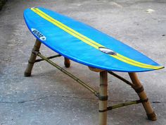 a blue surfboard sitting on top of a wooden bench