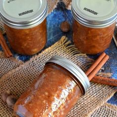 two jars filled with cinnamon butter next to cinnamon sticks