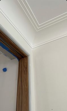 a bathroom mirror with blue paint on the wall and wood trim around it's edge