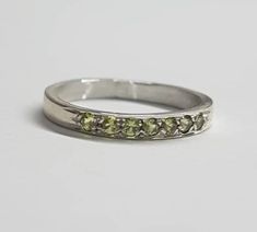 Handmade delicate half eternity stacking ring, stoned with 7 beautiful light green gemstones.  This multistone ring is beautiful alone or stacked together with other rings and is colorful and pretty on your finger.  The ring is available in nickel free, 14 karat gold plating over a brass or silver base. Can be also ordered in solid sterling silver, 9k or 14k solid gold.  A perfect beautiful gift for yourself or for a women you love. Dimensions: The ring width is about 2 mm. Multiple ring sizes a Green Half Eternity Stackable Rings For Anniversary, Green Toe Ring For Promise, Green Stackable Promise Rings With Prong Setting, Green Gemstone Stackable Rings With Round Band, Green Half Eternity Stackable Rings As Gift, Green Half Eternity Promise Ring, Green Stackable Promise Ring, Green Stackable Round Band Rings, Green Gemstone Stackable Round Band Rings