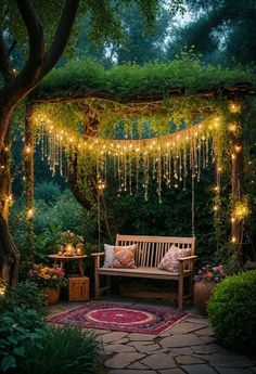 a wooden bench sitting under a lush green tree covered in fairy lights and string lights