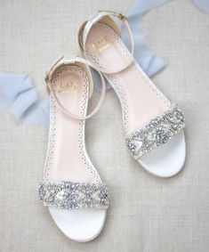 a pair of white shoes with silver sequins on the toes and heel straps