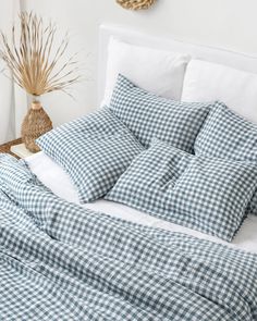 a blue and white checkered comforter on a bed in a room with a wicker basket