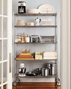 an open door leading to a pantry with shelves full of food and drinks on it