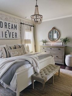 a bed room with a neatly made bed and a chandelier hanging from the ceiling