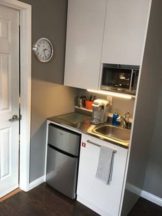 a small kitchen with white cabinets and stainless steel appliances