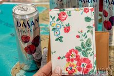 a can of soda and a wallet sitting on a table with other cans in the background