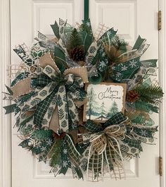 a christmas wreath hanging on the front door with a merry card attached to it's side