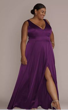 a woman in a long purple dress with her legs crossed and wearing high heeled shoes