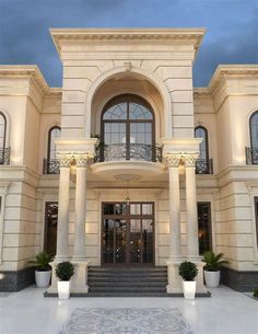 a large white building with columns on the front and stairs leading up to it's entrance