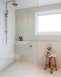 a bathroom with a stand up shower and white walls