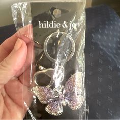 someone is holding up their phone case with the butterfly design on it, and its packaging has been wrapped in clear cellophane