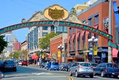 cars are parked on the side of the road in front of an arch that reads, historic heart of san diego