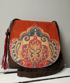 Orange and brown messenger bag Boho bag Vegan crossbody bag Oriental bag Medium sized bag Oriental purse Evening bag Christmas gift idea -Medium sized messenger bag with adjustable strap -Simple style -Flap with decorative badge -Inside lining with two pocket -Bag closed by magnet -Bag made from eco suede -Bag decorated with hand-made tassel Width 10,24- 11,81 in / 26- 30 cm height 9,84 in / 25 cm Care: wash in hands and lay flat to dry. Real colors may differ slightly from their appearance on y Medium Size Crossbody Purse, Brown Travel Flap Bag With Phone Pocket, Brown Travel Flap Bag With Mobile Phone Pocket, Travel Brown Flap Bag With Mobile Phone Pocket, Brown Crossbody Saddle Bag, Brown Pouch Flap Bag For Daily Use, Brown Pouch Saddle Bag For Travel, Brown Crossbody Flap Bag With Removable Pouch, Brown Crossbody Shoulder Bag With Mobile Phone Pocket