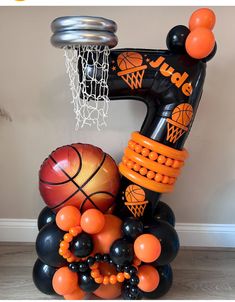 an inflatable basketball hoop with balloons and other sports items on it, as well as the number one