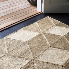 a brown rug sitting on top of a wooden floor next to a white door way