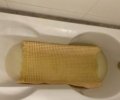 a bathtub with a yellow pillow in it