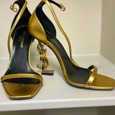 Ysl Logo Gold Heels! These Have Been So Popular Over The Years. Ive Worn It Few Times So You Can See Wear On It. Just Very Minimal Peeling (On Front Of Shoe And Side). Please Refer To Photos For Condition! Size 35 1/2 ! Its The Real Shoe. Beautiful Look, Again Worn A Few Times But Decent Condition! Shoes Ysl, Ysl Heels, Yves Saint Laurent Shoes, Ysl Logo, Saint Laurent Shoes, Gold Heels, Over The Years, Shoes Women Heels, Yves Saint Laurent